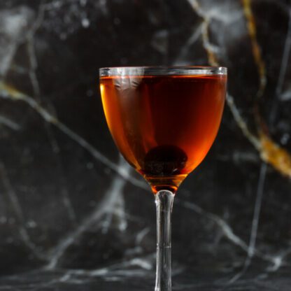 Left Hand Cocktail With Bourbon Campari Sweet Vermouth And Chocolate Bitters With A Brandied Cherry